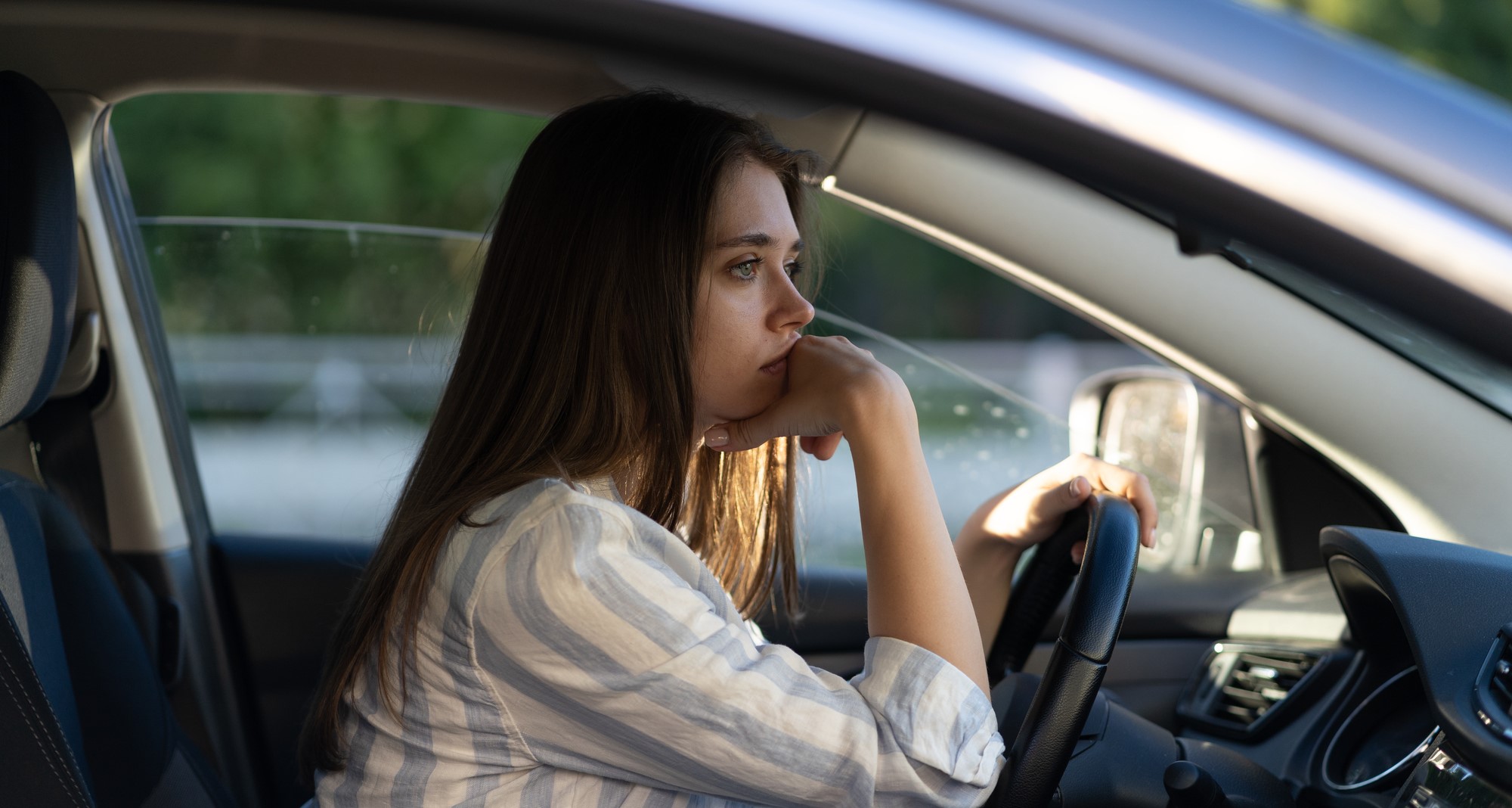 photo of a female struggling behind the wheel with PTSD, a common issue after being involved in a car accident, and grappling with the fear of driving after an accident